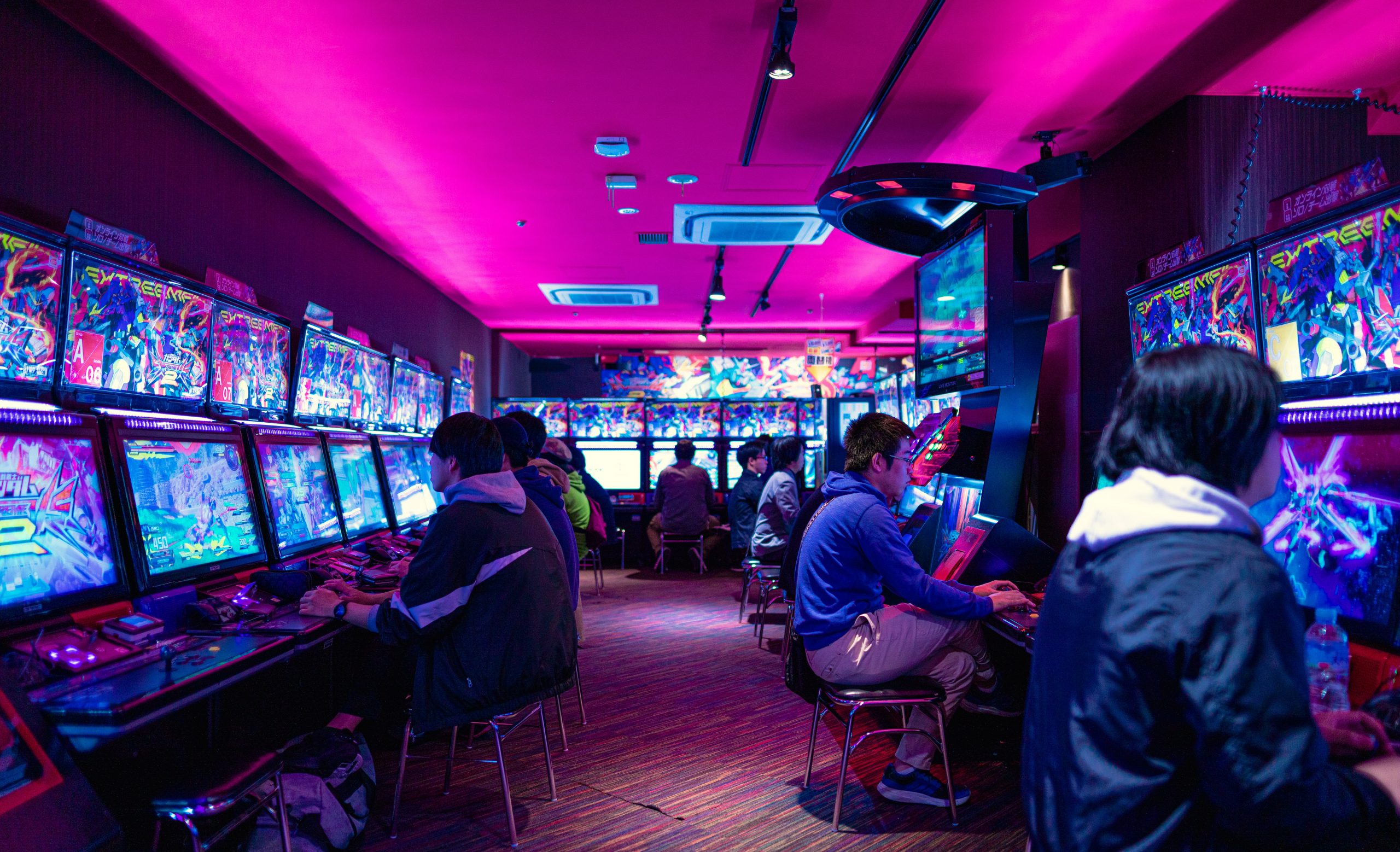 people playing video games in an arcade